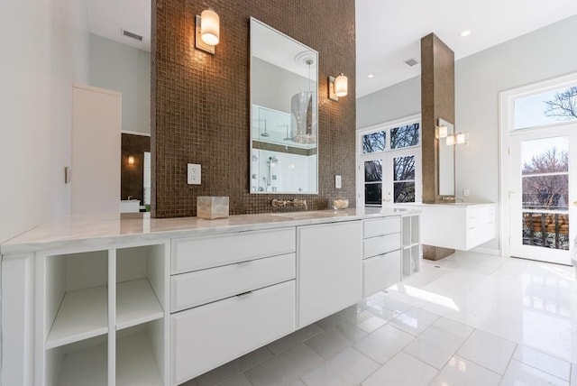 bathroom with a towering ceiling, visible vents, backsplash, and vanity