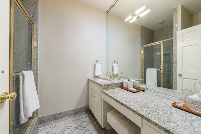 bathroom featuring a stall shower, vanity, and baseboards