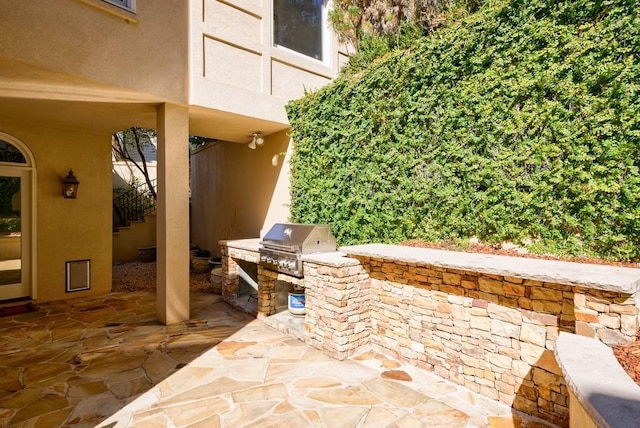 view of patio featuring stairs, exterior kitchen, and area for grilling