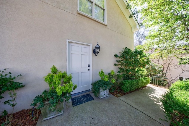 property entrance with a patio and stucco siding