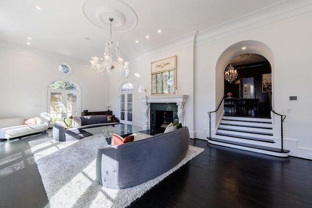 living area with a chandelier, dark wood-style flooring, baseboards, and a premium fireplace