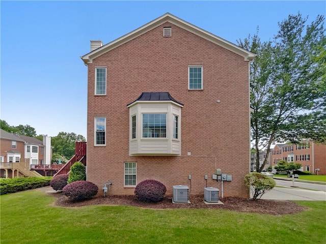 2231 Mill Garden Pl, Buford, GA 30519 - view of side of home featuring a chimney, brick siding, a lawn, and stairs