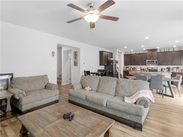 living room featuring light hardwood / wood-style flooring and ceiling fan