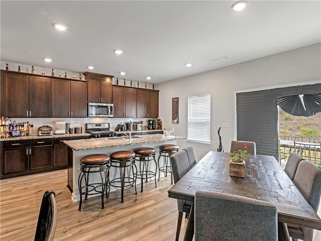 dining area featuring light wood-type flooring and sink