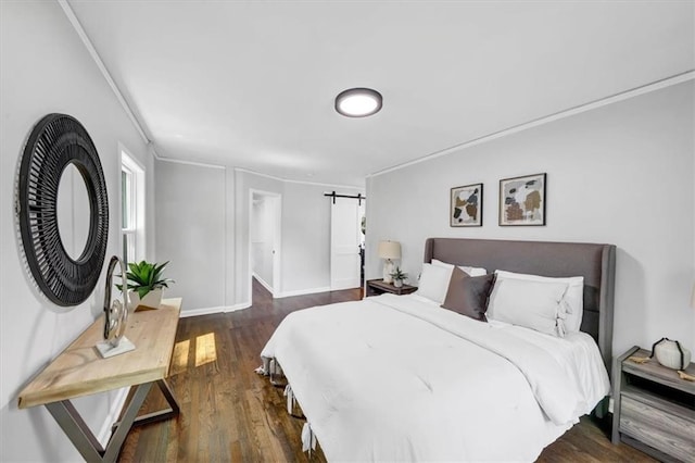 bedroom with dark hardwood / wood-style floors, a barn door, and crown molding