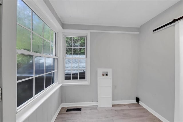 washroom featuring a barn door, washer hookup, and light wood-type flooring