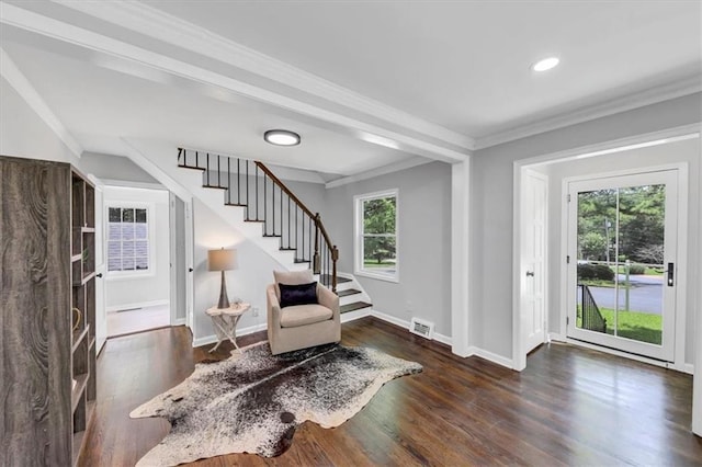 sitting room with ornamental molding and dark wood-type flooring