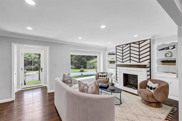 living room with hardwood / wood-style floors, built in features, and crown molding