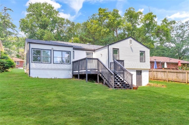 back of house featuring fence, a wooden deck, a lawn, and stairway