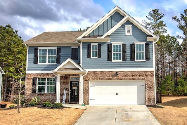 craftsman house with driveway, a garage, board and batten siding, and brick siding