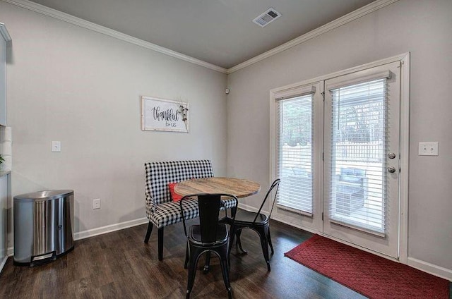 dining space featuring dark wood-style floors, baseboards, visible vents, and ornamental molding