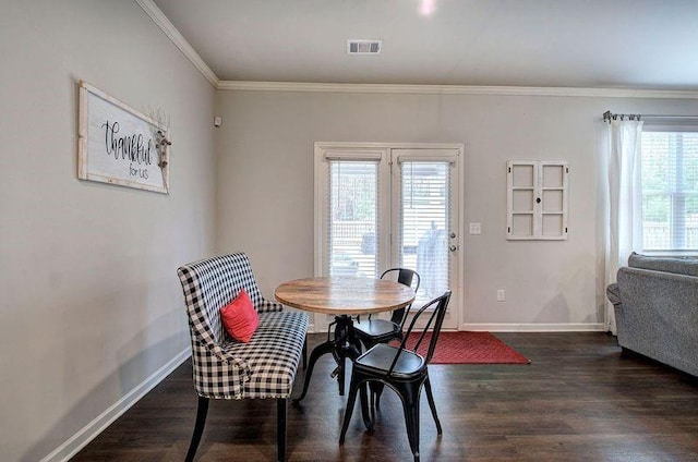 dining space featuring dark wood-style floors, baseboards, visible vents, and crown molding