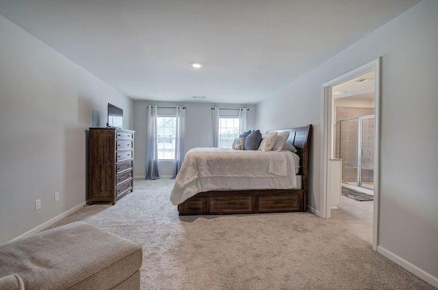 bedroom featuring light carpet, connected bathroom, and baseboards