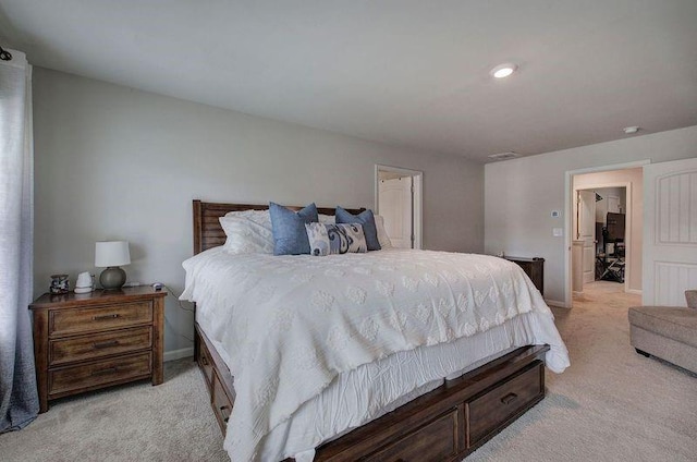 bedroom with light colored carpet and baseboards