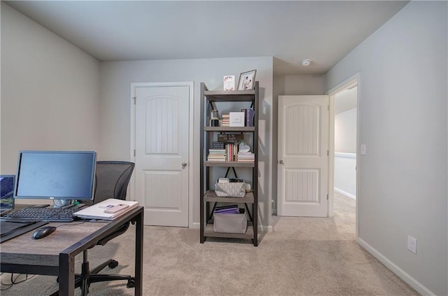 office area featuring baseboards and light colored carpet