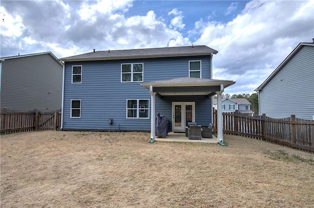 rear view of property featuring a fenced backyard, french doors, and a patio