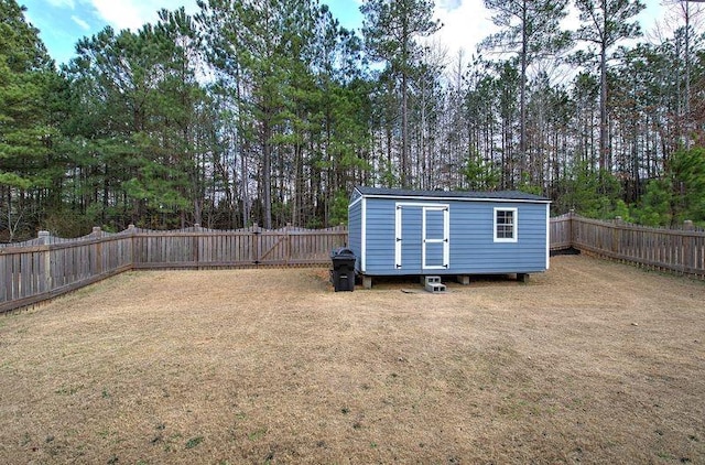 rear view of property with an outbuilding, a yard, a storage unit, and a fenced backyard