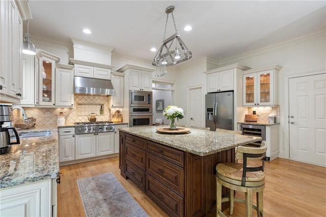 kitchen with stainless steel appliances, under cabinet range hood, a sink, backsplash, and wine cooler