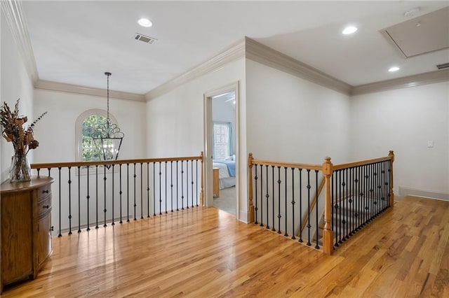 hall featuring attic access, wood finished floors, an upstairs landing, crown molding, and recessed lighting