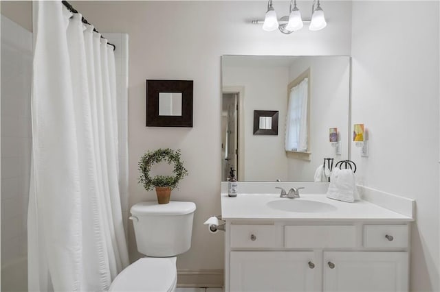 bathroom with toilet, vanity, and baseboards