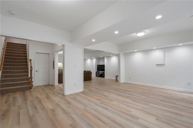 unfurnished living room with stairs, light wood finished floors, recessed lighting, and baseboards