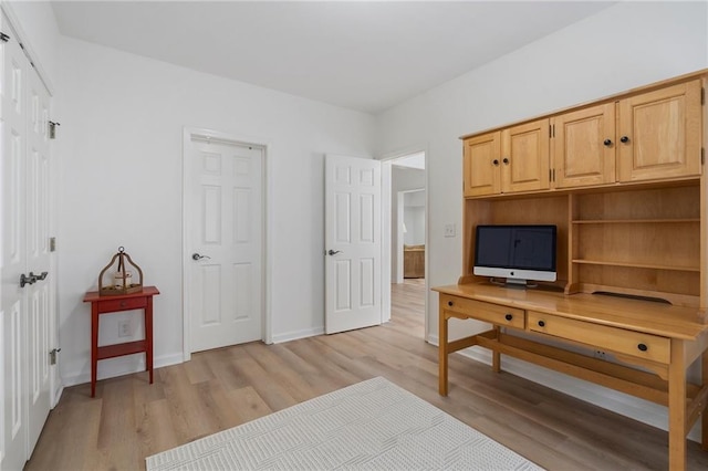 home office featuring light wood-type flooring and baseboards