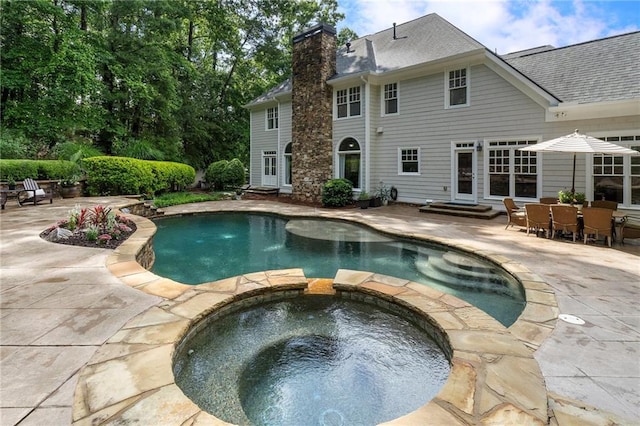 view of swimming pool with entry steps, a patio area, and a pool with connected hot tub