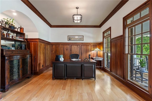 home office featuring light wood-type flooring, a wainscoted wall, and ornamental molding