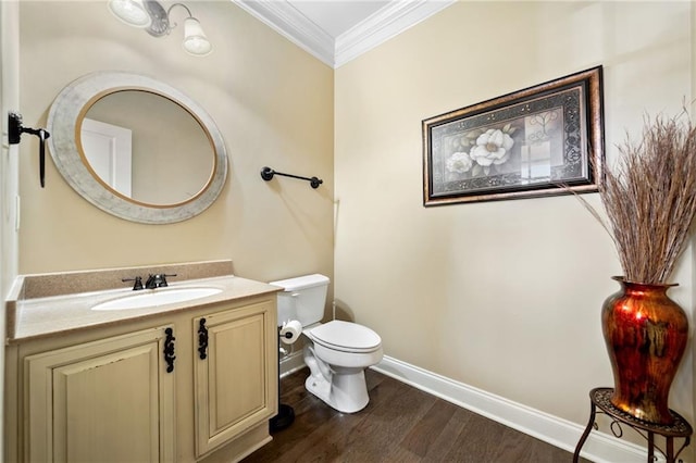 bathroom with vanity, toilet, ornamental molding, baseboards, and wood finished floors