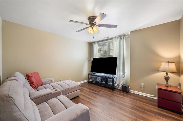 living room with baseboards, visible vents, wood finished floors, and a ceiling fan