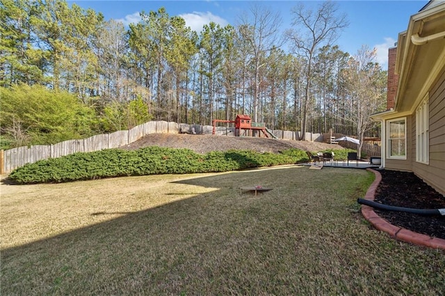 view of yard with a fenced backyard and a playground