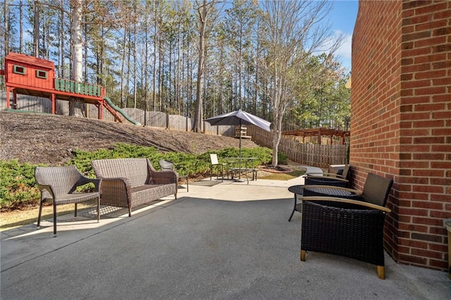 view of patio featuring a fenced backyard and a playground