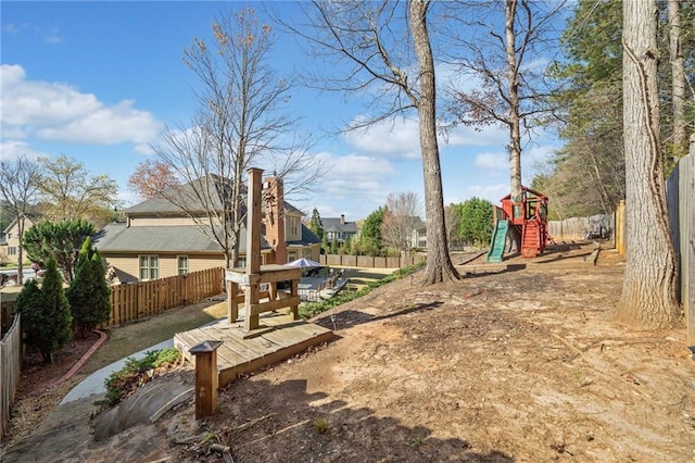view of yard featuring playground community and fence