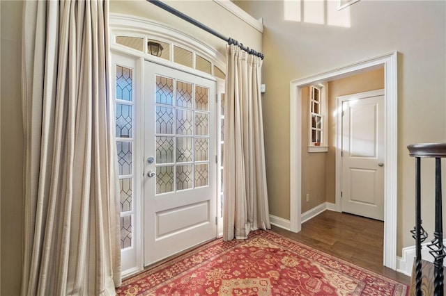 foyer entrance featuring baseboards and wood finished floors