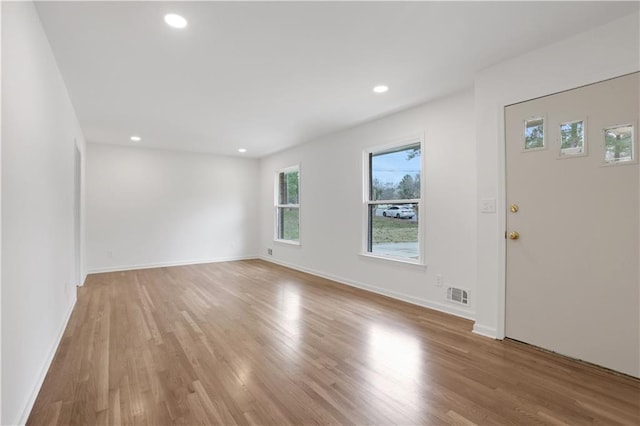 interior space with light wood-style floors, recessed lighting, visible vents, and baseboards