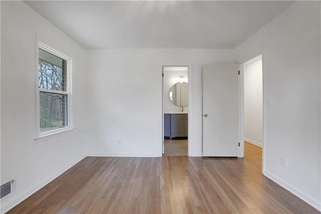 unfurnished bedroom with baseboards, visible vents, and wood finished floors