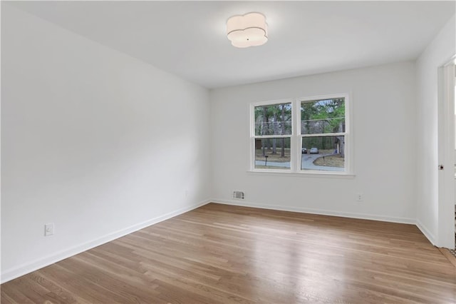 unfurnished room with baseboards, visible vents, and light wood-style floors