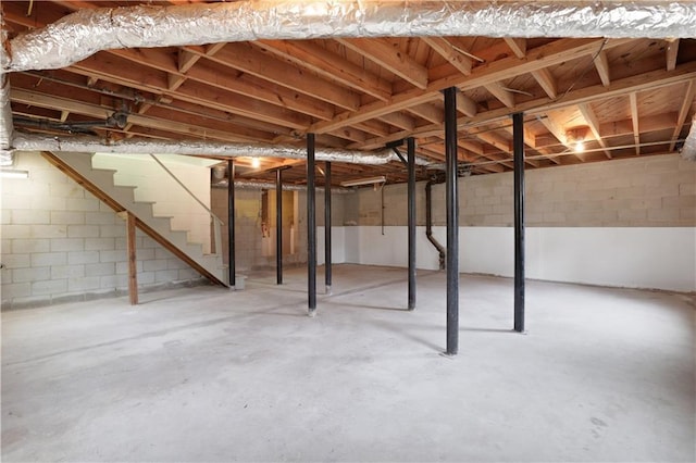 unfinished basement featuring stairway