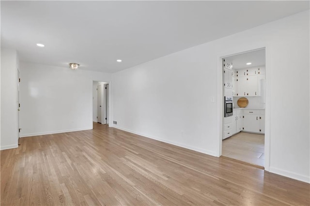 empty room with recessed lighting, light wood-style flooring, and baseboards