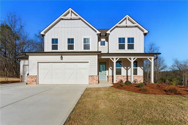 20 Running Ter NW, Cartersville, GA 30121 - view of front facade with a garage, brick siding, a front lawn, board and batten siding, and driveway