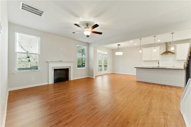 20 Running Ter NW, Cartersville, GA 30121 - unfurnished living room with light wood-style flooring, visible vents, baseboards, a ceiling fan, and a sink