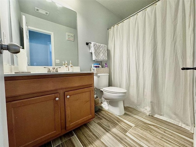 bathroom featuring vanity, curtained shower, and toilet