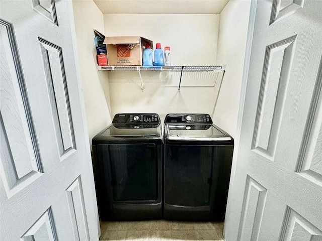 washroom featuring light tile patterned flooring and washing machine and clothes dryer