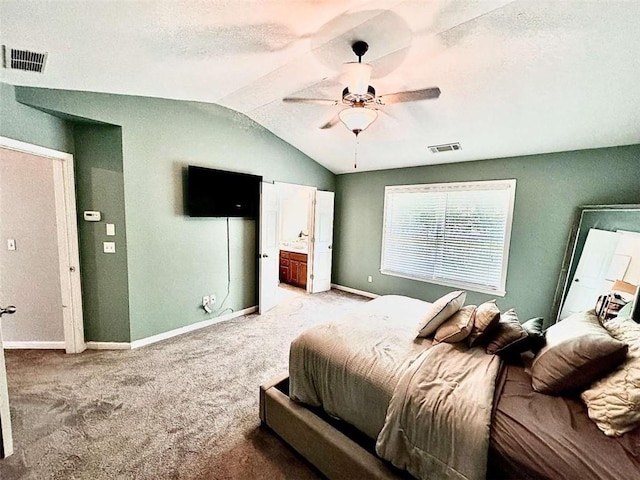 carpeted bedroom featuring a textured ceiling, ceiling fan, ensuite bathroom, and lofted ceiling