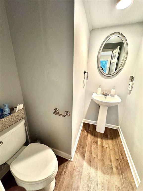 bathroom with toilet and wood-type flooring