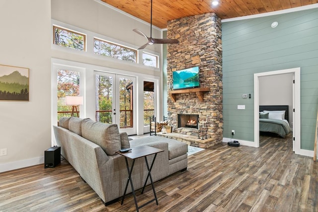 living room featuring french doors, wood ceiling, ceiling fan, high vaulted ceiling, and a stone fireplace