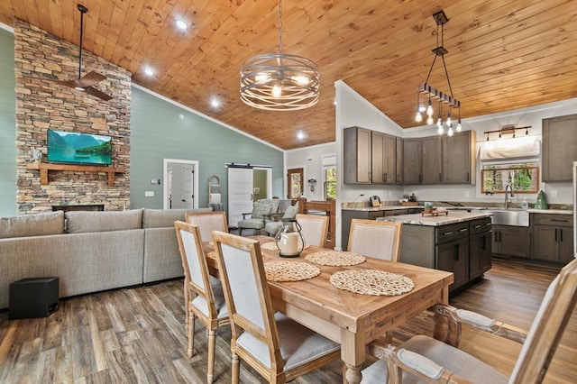 dining area featuring a barn door, plenty of natural light, high vaulted ceiling, and hardwood / wood-style flooring