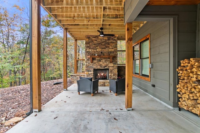 view of patio with an outdoor stone fireplace and ceiling fan