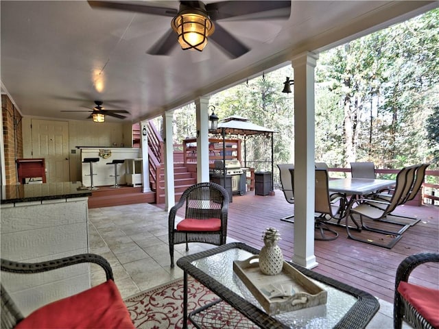 exterior space with a wooden deck, a gazebo, ceiling fan, and a grill