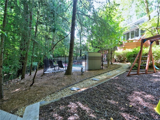 view of yard featuring a fenced in pool and a playground